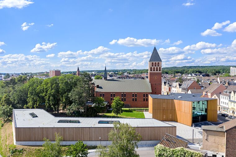 Das von Atelier Brückner aus Stuttgart geplante Gebäudeensemble bildet vor der historischen Kulisse der Kirche einen großzügigen Spielhof aus, der teils befestigt, teils Garten ist. Zwischen dem steinernen Bestand und den Neubauten aus Holzlamellen entfaltet sich ein spannungsreicher Dialog. Architektur: ATELIER BRÜCKNER. Foto: Daniel Stauch