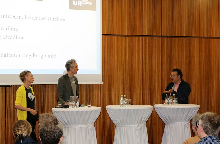 Britta Jürgens und Matthew Griffin von Deadline Architekten im Gespräch mit Peter Cachola Schmal, Direktor des Deutschen Architekturmuseums Frankfurt a. M., während der Eröffnung der Ausstellung zum „Mies van der Rohe Award 2022“ im LVR-Landeshaus in Köln. Foto: Timo Klippstein