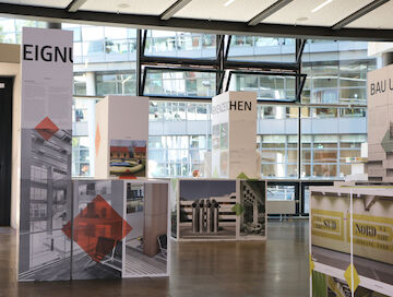 Die Ausstellungsmodule bestehen aus Kartonwürfeln und bilden zusammen ein Ensemble, dass an eine begehbare Stadt erinnert. | Foto: Timo Klippstein