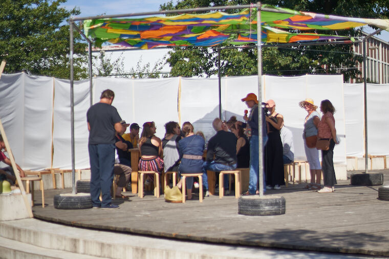Diskussion unter der von Studierenden gemeinsam mit raumlabor berlin entwickelten Schirmkonstruktion.