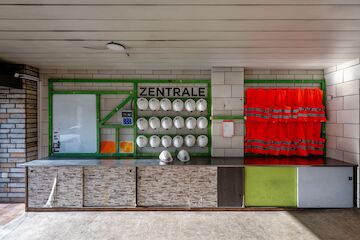 Die Zentrale des UmBauLabors von Baukultur NRW: Der Infopunkt im Erdgeschoss bietet Gelegenheit, um mit der Nachbarschaft und Interessierten ins Gespräch zu kommen und sich über Umbauprozesse auszutauschen. In der Zentrale hängen Westen und Helme, die für eine Begehung des Gebäudes erforderlich sind. | Foto: Tania Reinicke