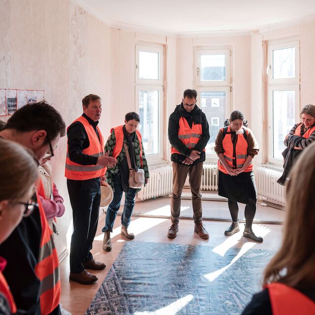 Besichtigen die ehemaligen Wohnräume des Gebäudes an der Bergmannstraße 23 in Gelsenkirchen: Gäste der Auftaktveranstaltung des UmBauLabors von Baukultur NRW.