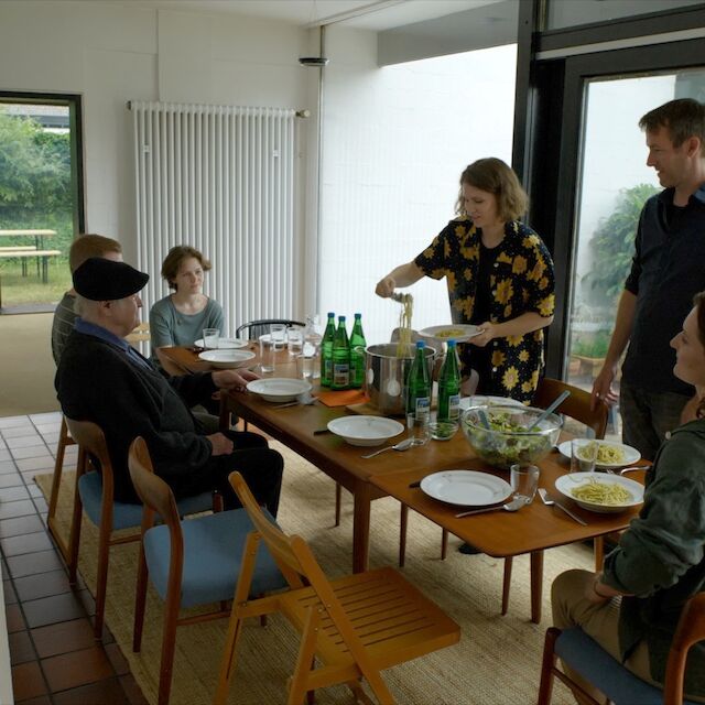 Begegnungen im Pehnthaus: Der Architekt des Wohnhauses von Wolfgang Pehnt, Wolfgang Meisenheimer (sitzend mit Mütze), zu Gast bei den aktuellen Bewohnerinnen. Stehend Prof. Dr. Daniel Lohmann von der TH Köln.