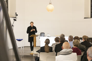 Ausstellungseröffnung „Kirchen als Vierte Orte“, Berger Kirche, Düsseldorf, 9.11.2025. Kurator Felix Hemmers von Baukultur NRW führte in die Ausstellung ein. | Foto: Claudia Dreyße