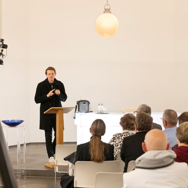 Erläutert die Idee der Ausstellung „Kirchen als Vierte Orte – Perspektiven des Wandels“ während der Eröffnung in der Berger Kirche in Düsseldorf am 9.11.2025.