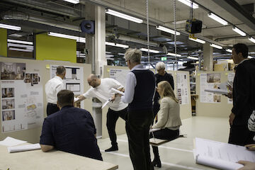 Großes Interesse, intensive Diskussion: die Jury des Wettbewerbs „Raum im Raum“ bei der Arbeit in der Werkstatt der Peter Behrens School of Arts der Hochschule Düsseldorf. Foto: Leyla Oduncu