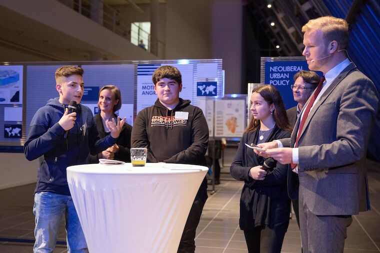 Moderator Tobias Häusler fragt Schülerin und Schüler der Gesamtschule Ückendorf nach ihrem Stadtteil. Foto: Claudia Dreyße.